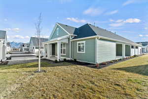View of property exterior with a lawn, roof with shingles, and board and batten siding