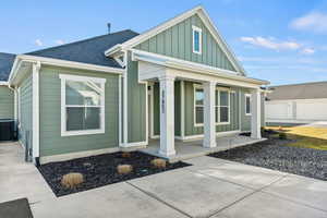 View of front of home featuring covered porch, board and batten siding, and a shingled roof