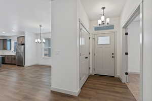 Foyer featuring a chandelier and dark wood-type flooring