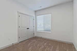 Unfurnished bedroom with carpet flooring and a closet