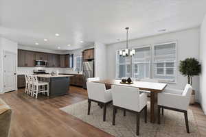 Dining space featuring dark wood-type flooring, recessed lighting, and a chandelier