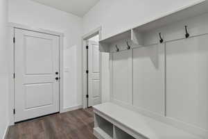 Mudroom featuring dark wood-type flooring and baseboards