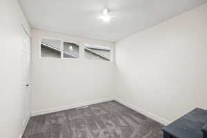 Spare room with a textured ceiling and dark carpet