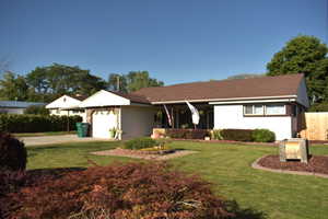 Ranch-style house with a garage and concrete driveway