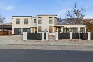 View of front of property with a fenced front yard, stucco siding, concrete driveway, and an attached garage