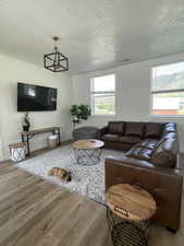 Living area with a textured ceiling and light wood-style flooring