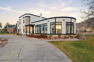 Back of property featuring a lawn and stucco siding