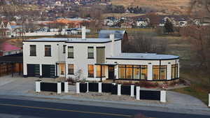 View of front facade featuring driveway, a garage, a chimney, and a residential view