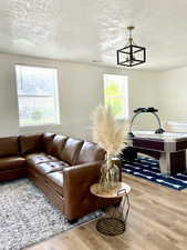 Living room featuring light wood finished floors and a textured ceiling