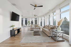 Living area with light wood-type flooring and ceiling fan