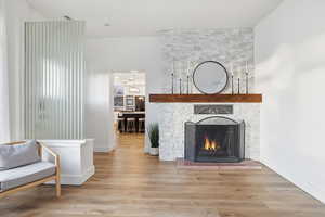 Sitting room featuring wood finished floors and a large fireplace