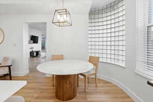 Dining space with light wood-style floors and a chandelier