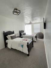 Carpeted bedroom with baseboards and a textured ceiling