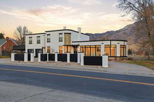 Contemporary home featuring a fenced front yard, stucco siding, and a mountain view