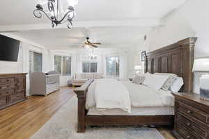 Bedroom with a chandelier, wood finished floors, beamed ceiling, and ceiling fan