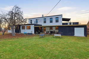 Rear view of property featuring a patio, a yard, and stucco siding