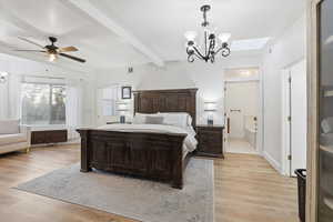 Bedroom with a chandelier, beam ceiling, light wood-type flooring, a skylight, and ensuite bath