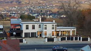 View of front of home with driveway, stucco siding, and a residential view