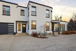 View of front facade featuring concrete driveway and stucco siding