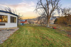 Yard at dusk featuring a yard and a mountain view