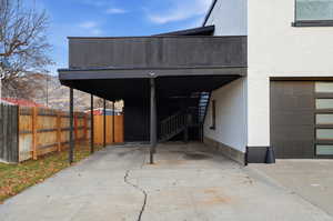 View of car parking with concrete driveway and an attached carport
