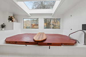 Detailed view of a skylight, beamed ceiling, and wood walls