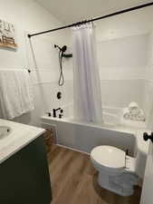 Bathroom with tiled shower / bath, vanity, and wood finished floors