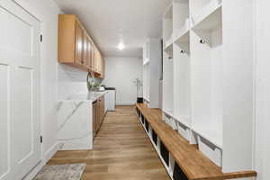 Mudroom featuring light wood-type flooring and baseboards
