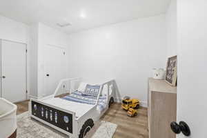 Bedroom with wood finished floors and attic access