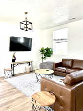 Living room with light wood-style flooring and a textured ceiling