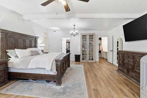 Bedroom featuring a spacious closet, ceiling fan, a chandelier, light wood-style flooring, and beam ceiling