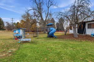 View of green lawn featuring a playground