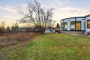 Yard at dusk featuring a lawn