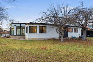 View of side of property featuring a sunroom and a lawn