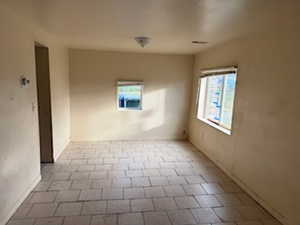 Unfurnished room featuring healthy amount of natural light and tile patterned flooring