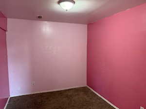 Spare room with dark colored carpet