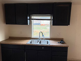 Kitchen featuring dark cabinetry and light countertops