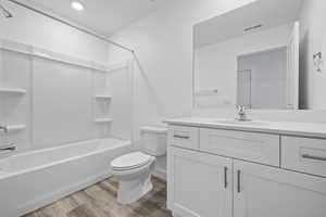 Bathroom with vanity, washtub / shower combination, and light wood finished floors