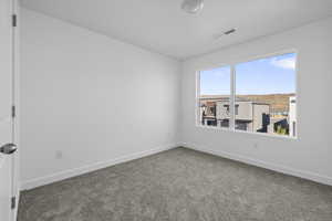 Empty room featuring carpet flooring and baseboards