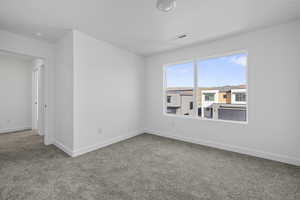 Carpeted empty room with baseboards