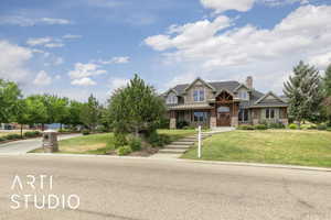 Craftsman house with stone siding, a front lawn, covered porch, and a chimney