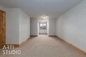 Spare room featuring baseboards and light carpet