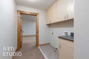 Washroom featuring cabinet space, hookup for a washing machine, light colored carpet, and hookup for an electric dryer