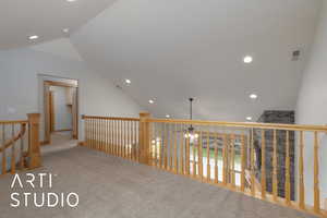 Corridor featuring recessed lighting, carpet floors, vaulted ceiling, and an upstairs landing