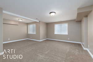 Spare room with baseboards and light colored carpet