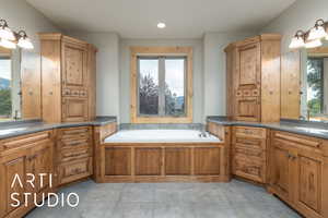 Full bathroom featuring a bath, healthy amount of natural light, two vanities, and recessed lighting