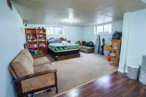 Bedroom with multiple windows and wood finished floors