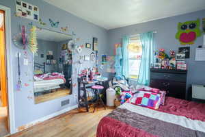 Bedroom with hardwood / wood-style flooring and baseboards