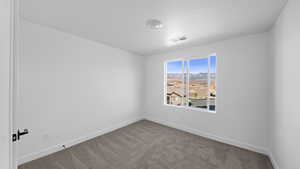 Carpeted spare room with a mountain view and baseboards