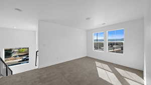 Carpeted spare room with baseboards and a mountain view